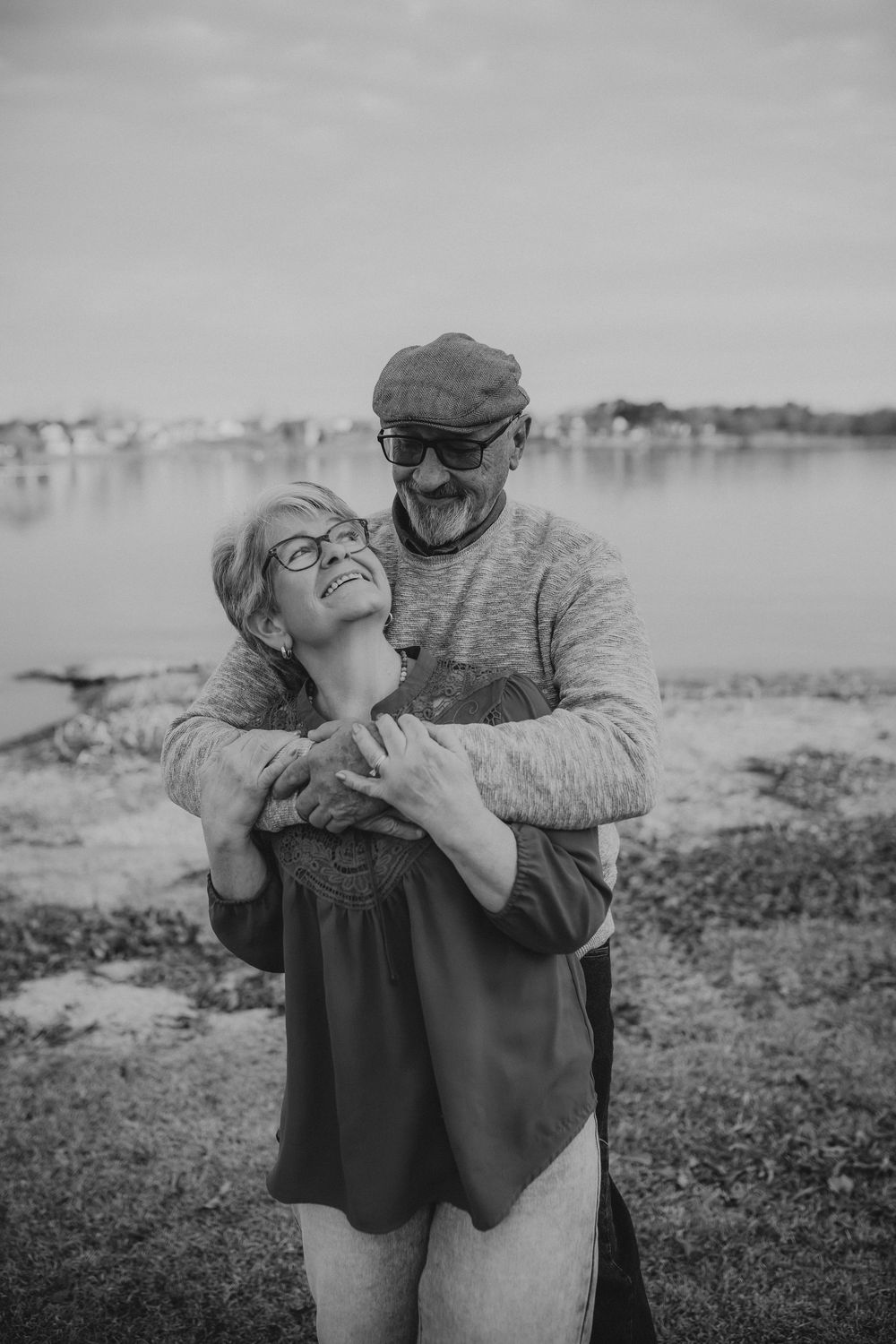 A romantic black and white photo sequence shows a couple embracing and dancing together by the water.
