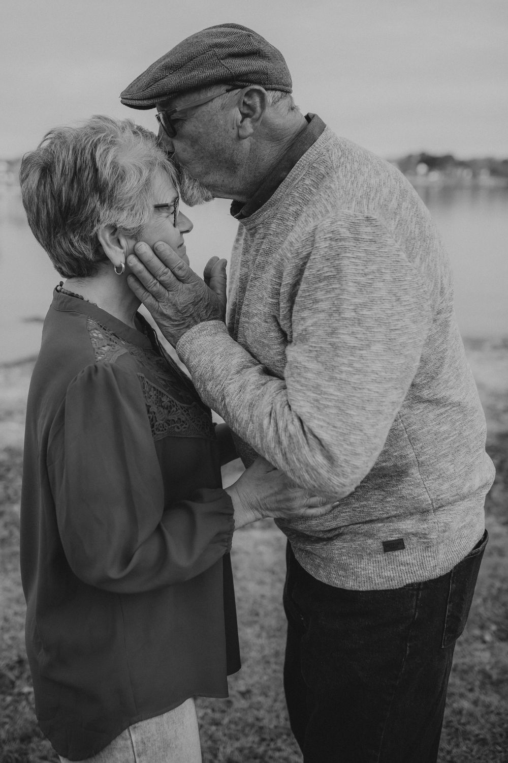 A tender moment between two people embracing outdoors, shown in a series of black and white photographs.