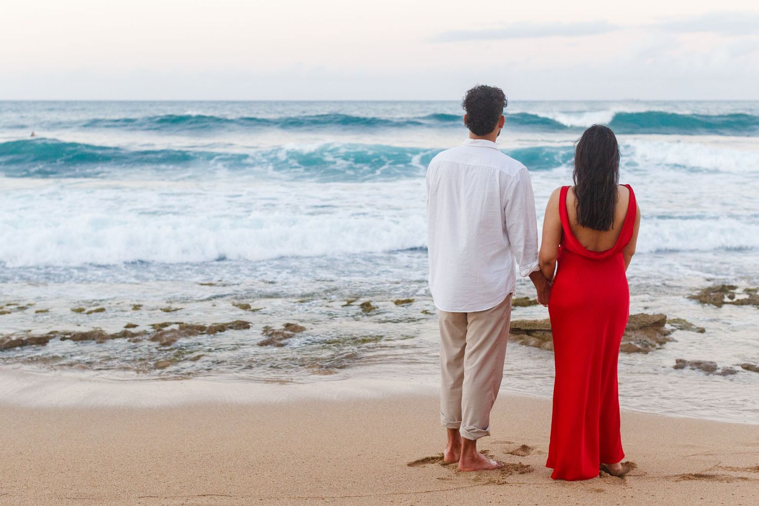 Couples portrait. Proposal and engagement session. Man and woman on the beach facing the ocean. Kikita Surf Beach, Dorado, Puerto Rico.