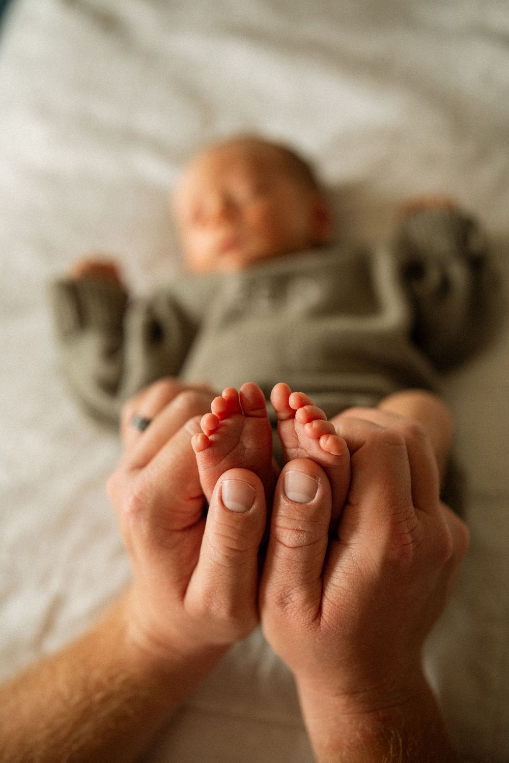Close-up photos of tiny newborn baby feet being gently held by adult hands.
