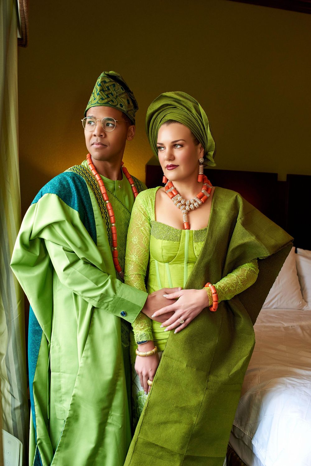 Black and White couple dressed in Nigerian and african outfit for their traditional wedding in a hotel room in green outfit