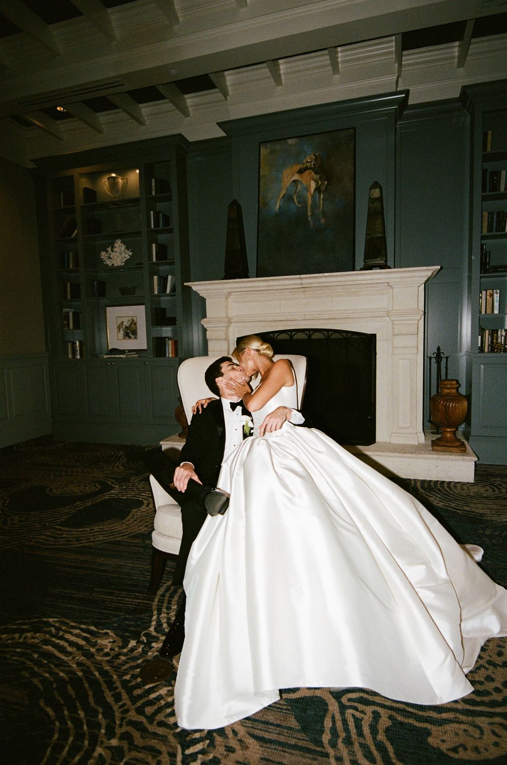 A romantic wedding couple sharing intimate dance moments in an elegant dark-walled room.