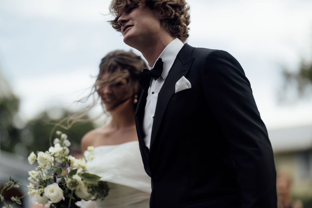 Romantic black and white wedding photo series showing tender moments between newlyweds in an outdoor setting.