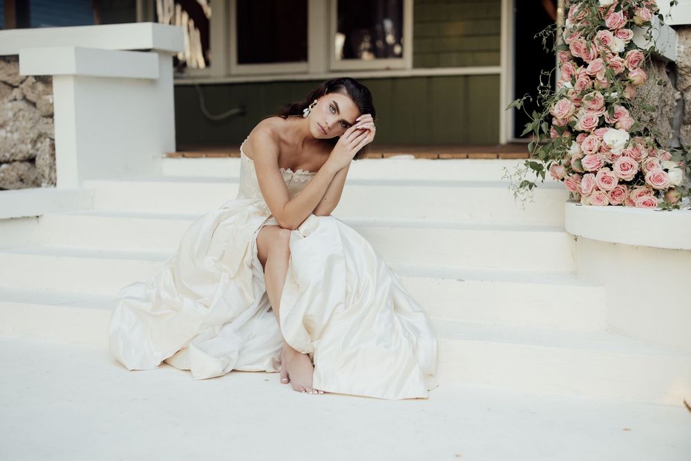 Intimate wedding moment captured on white porch with pink floral decorations.