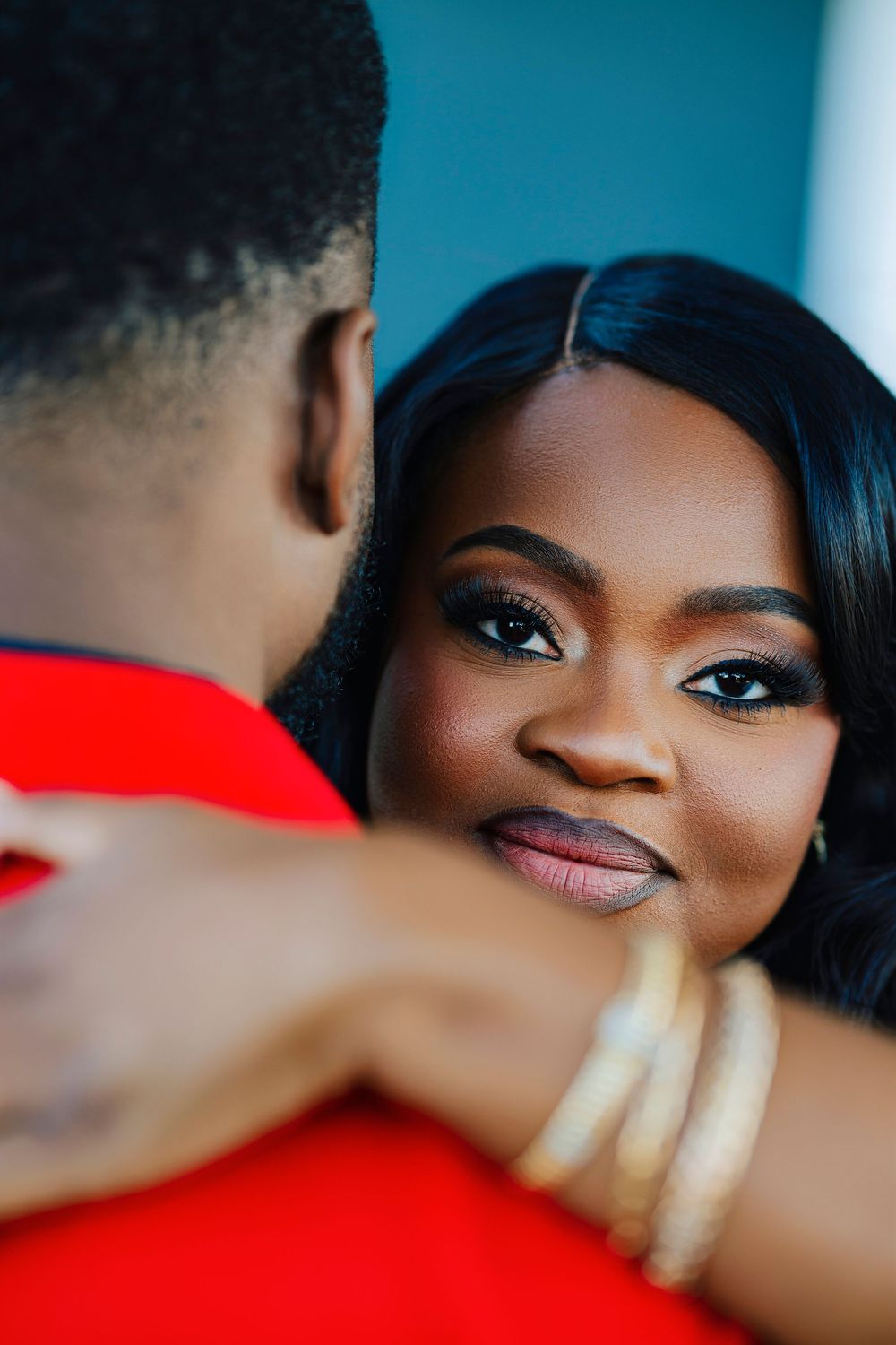 Close-up portraits showcase elegant couple in red and black attire during romantic photoshoot session.