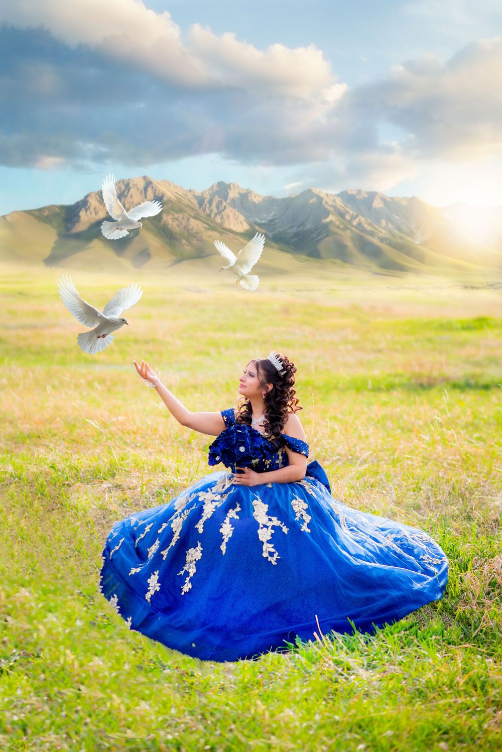 A magical portrait of a royal blue ball gown with white doves against a mountain landscape.
