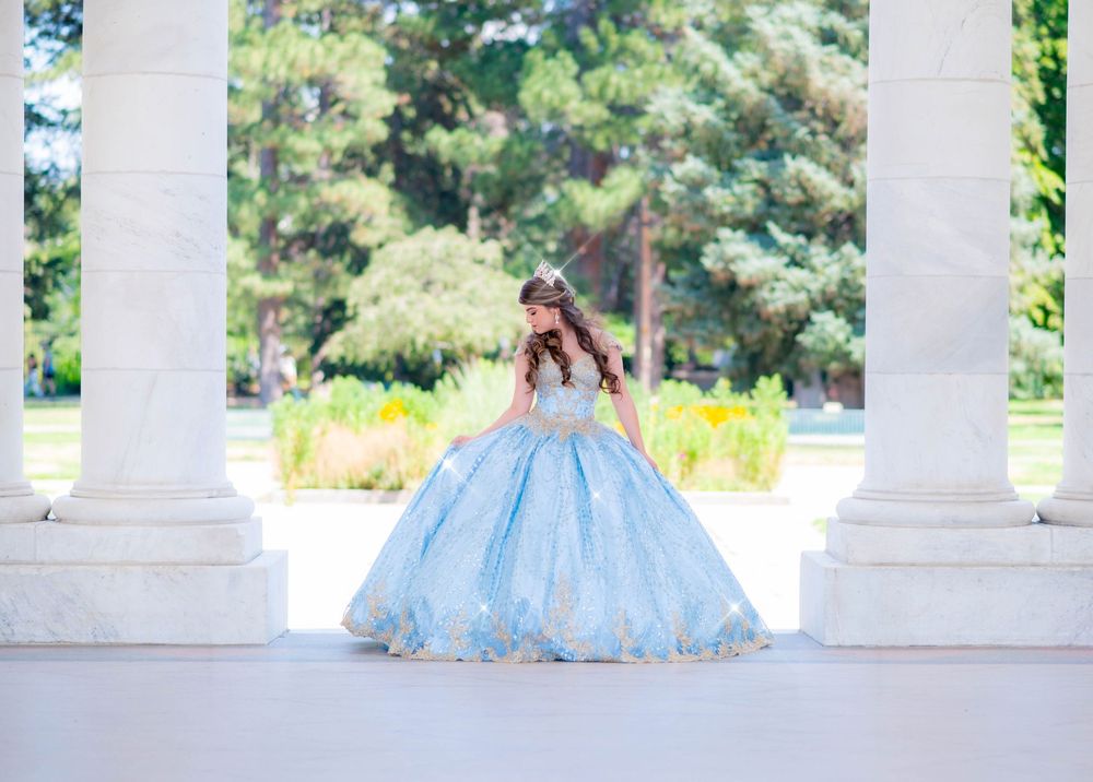 Light blue ballgown dress photographed in front of white columned architecture.