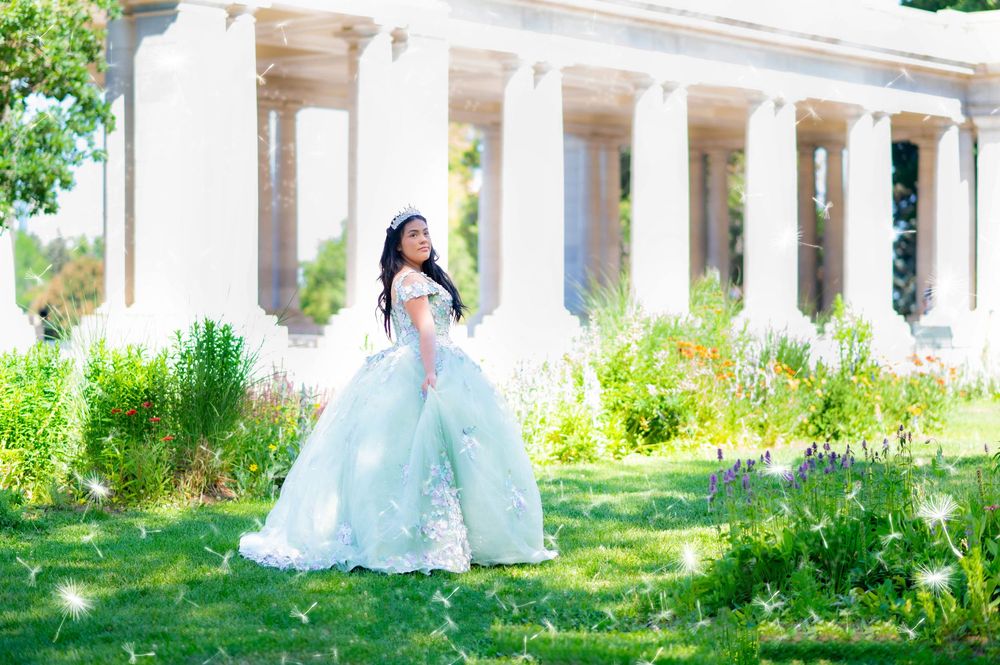 A dreamy mint green ball gown photographed in front of classical white columns and garden scenery.