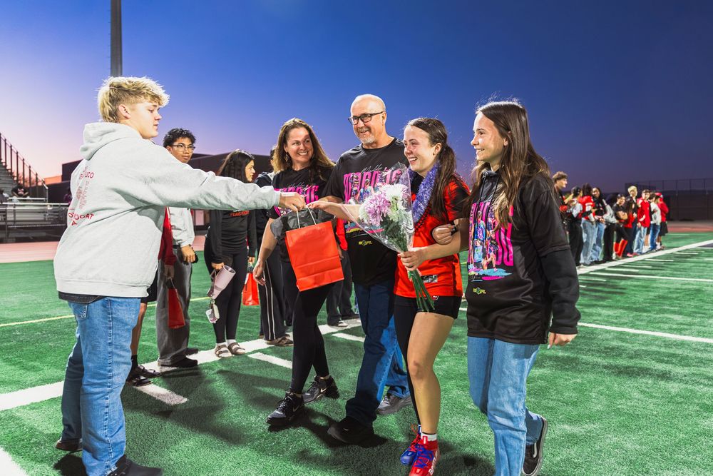 Girls flag football player and her family walking during senior night