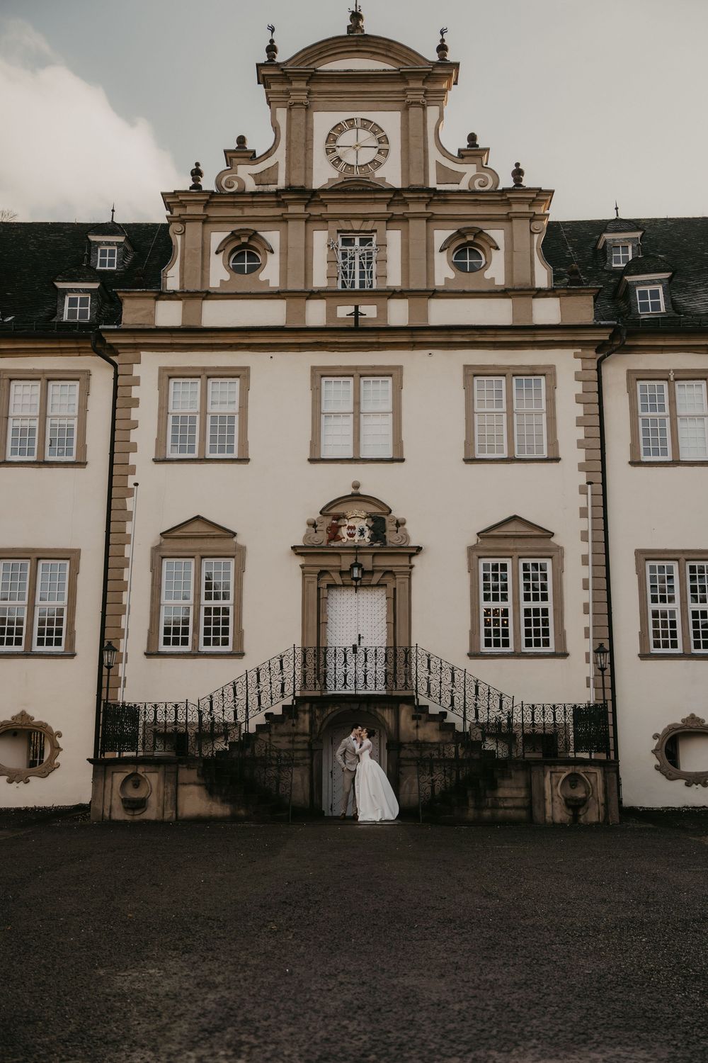 Historic baroque mansion with ornate architectural details and grand staircase captured in moody black and white photography.