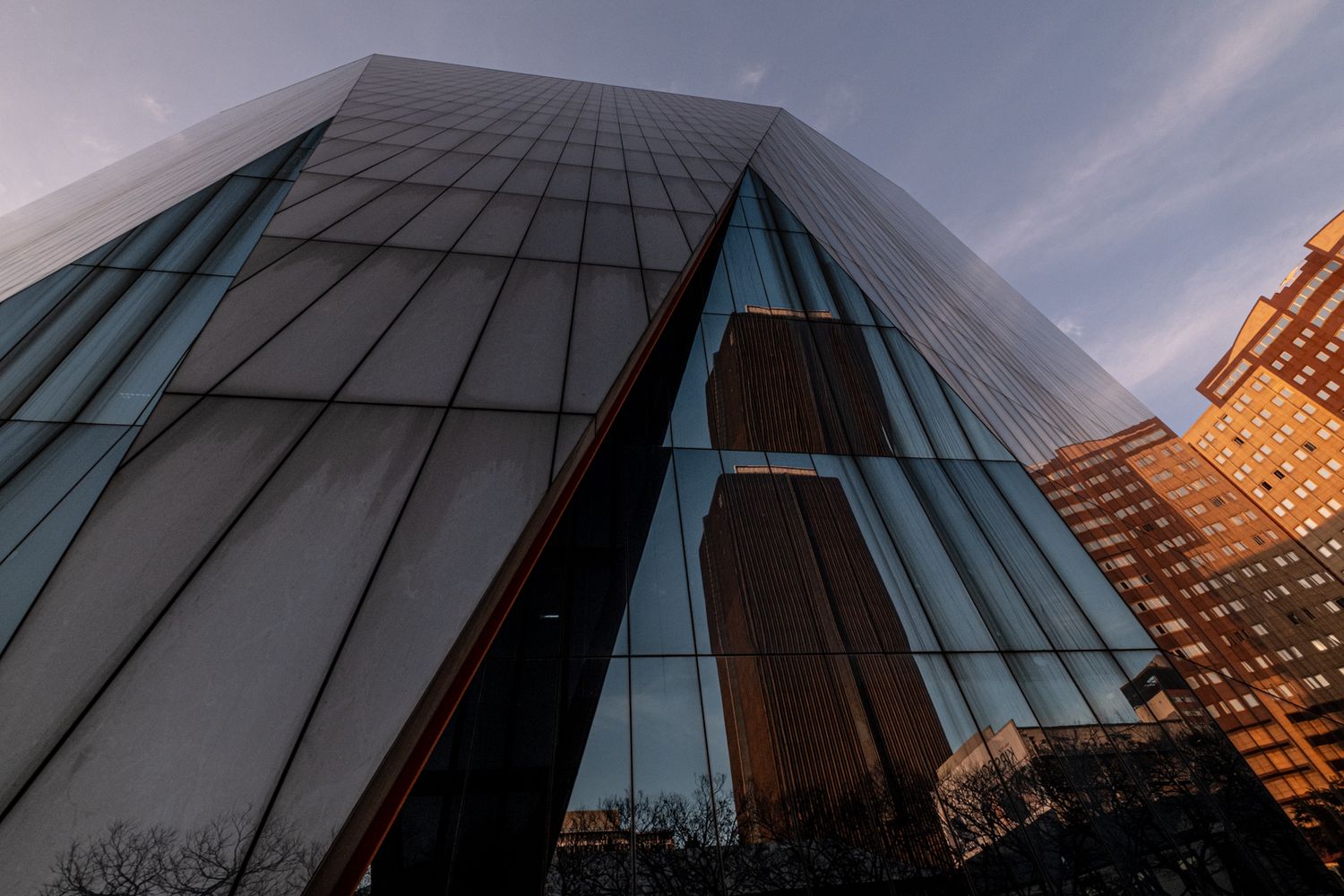 Glass office building viewed from below with reflective windows in Johannesburg, symbolising elevated photography skills.