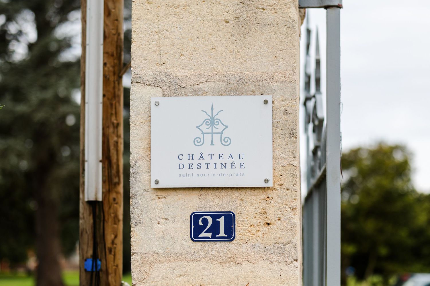 A close-up view of a house number 21 mounted on a beige wall with decorative details and signage.