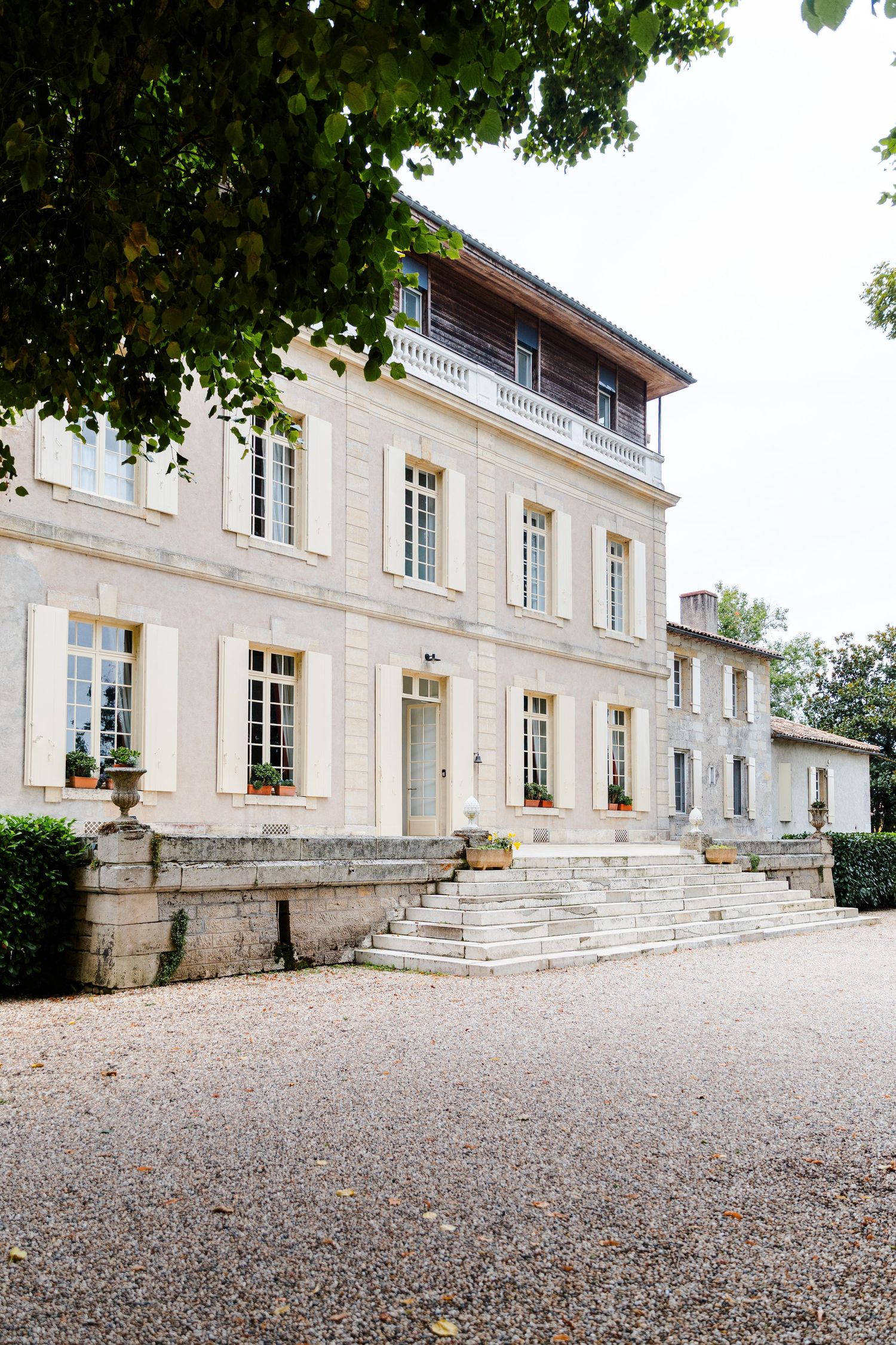 Elegant French chateau with white stone facade and grand entrance steps viewed from multiple angles on a gravel driveway.