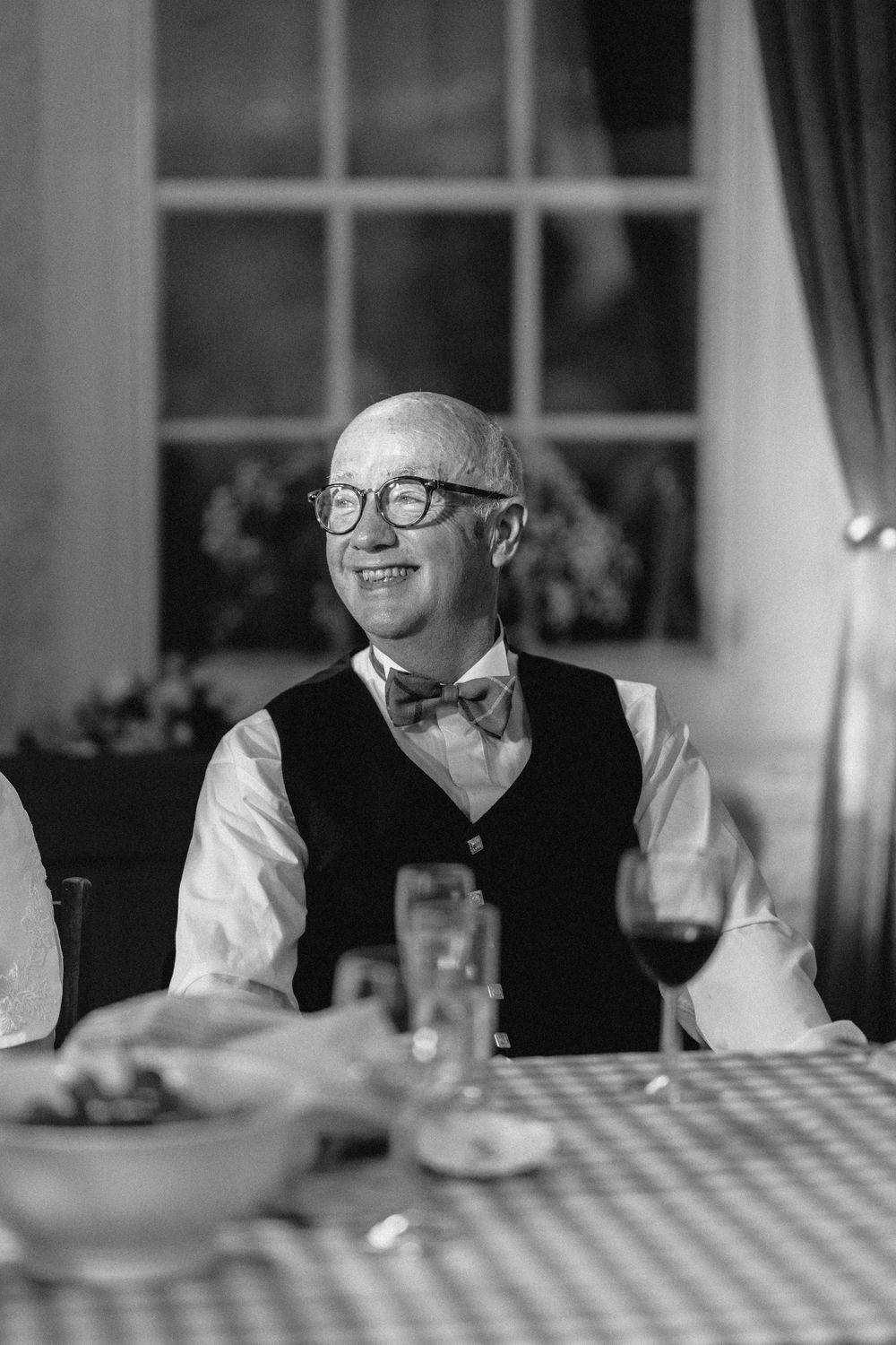 A black and white candid sequence of a guest enjoying dinner at a reception table.