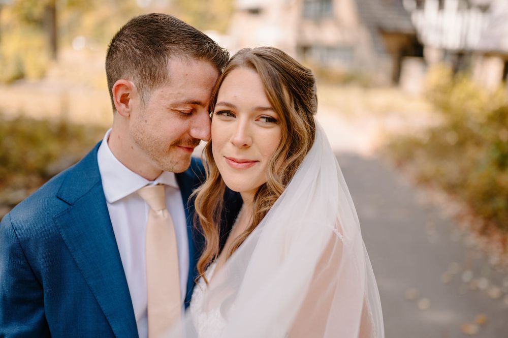 A bride and groom share an intimate moment outdoors on their wedding day in soft autumn light. at Cincinnati Nature Center