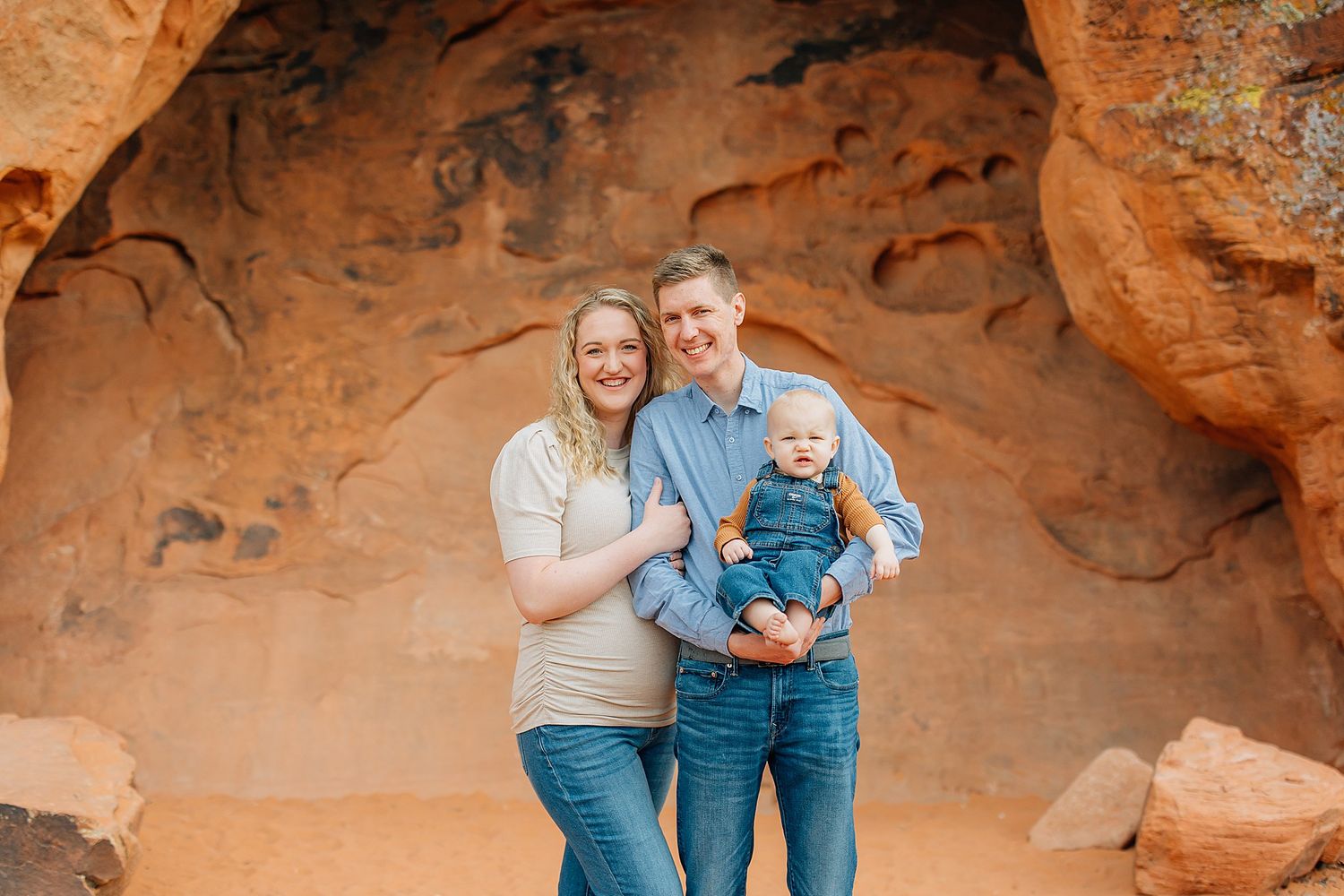 Family enjoying a photo session among stunning red rock formations in a desert landscape.