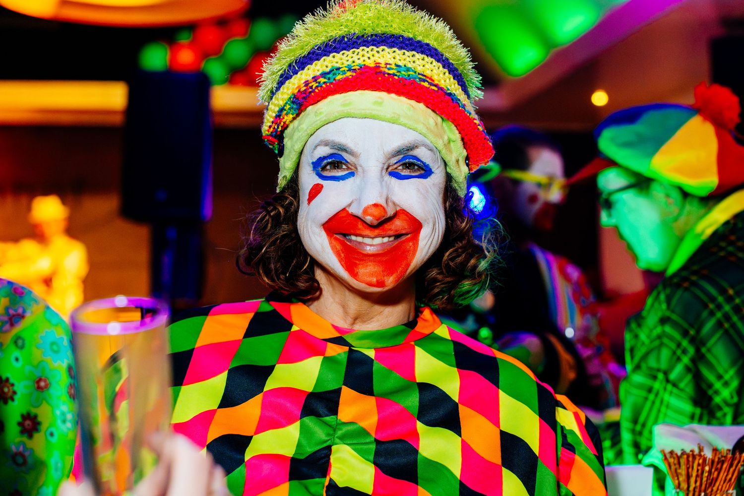 Two friends in colorful carnival costumes hugging and expressing authentic joy at an event. Vastelaovend in Venlo Vivitu