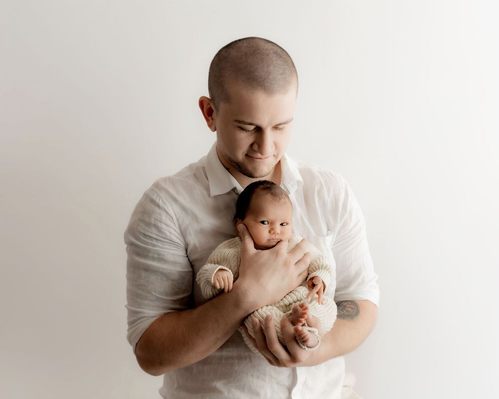 Father holding newborn baby during family photography session