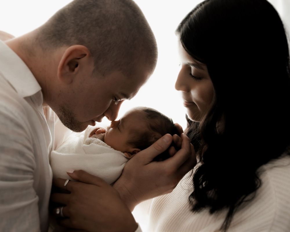 Newborn baby resting peacefully in parent's arms