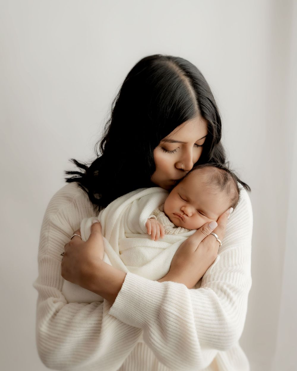 New mother cuddling their baby during newborn session