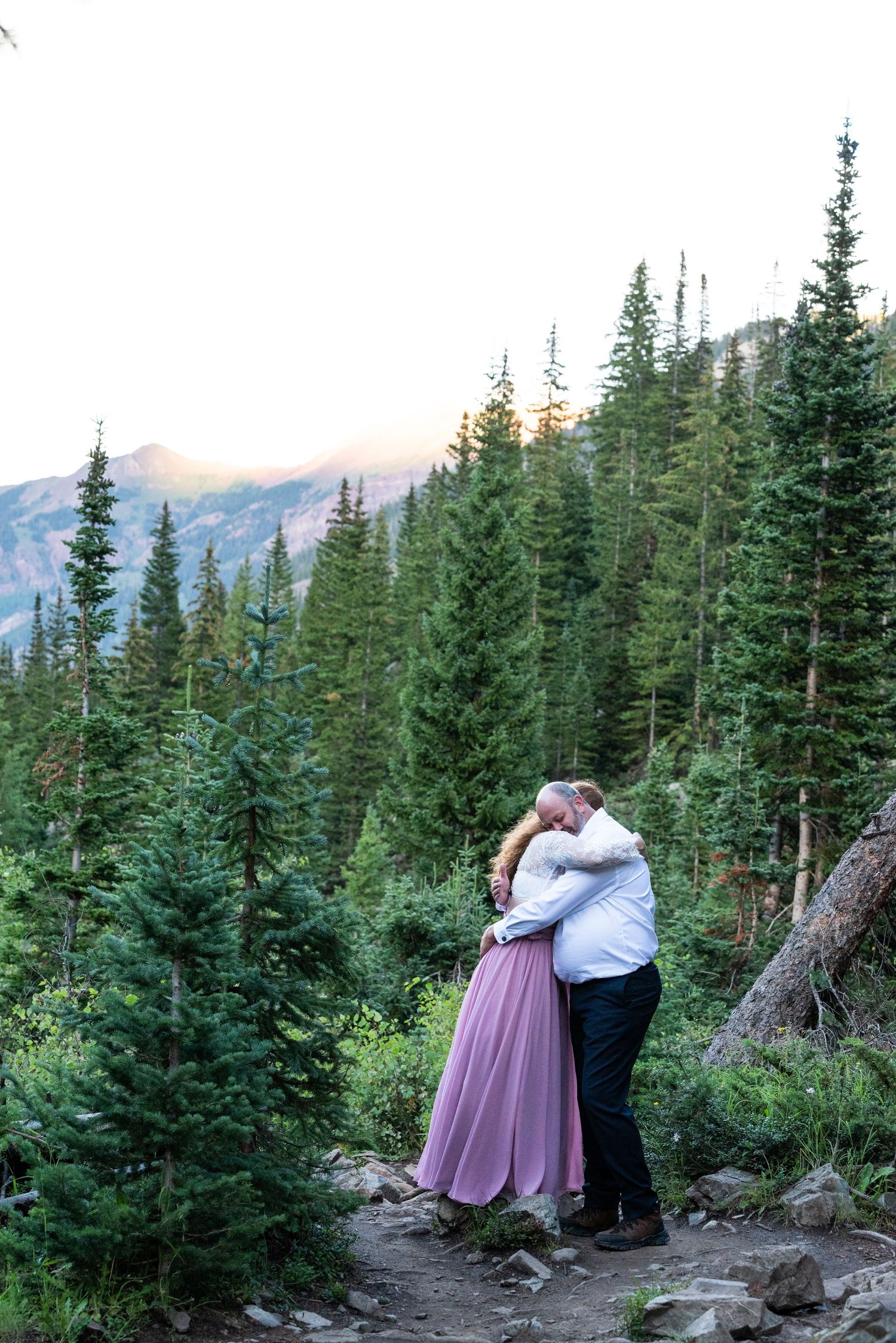 Intimate embrace among evergreen trees on mountain hiking trail.