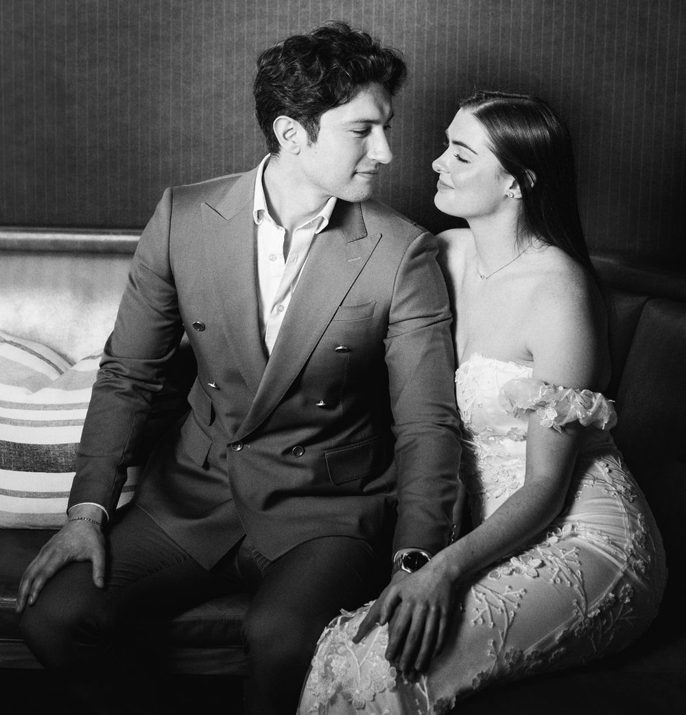 Black and white portrait of an elegant couple sitting closely together on a sofa.