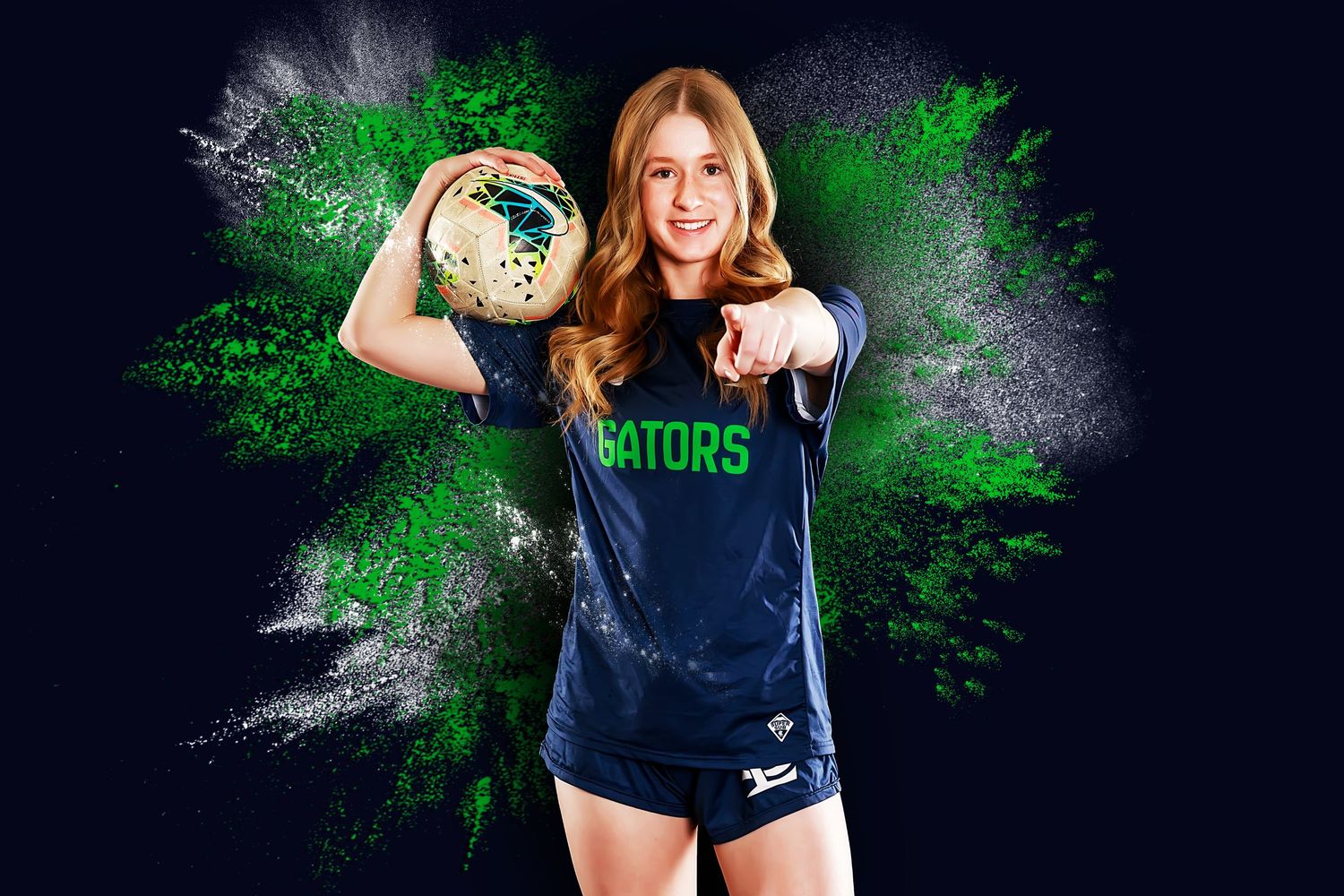 Athletic figure in navy blue sports uniform stands against dramatic dark background with green lighting effects.