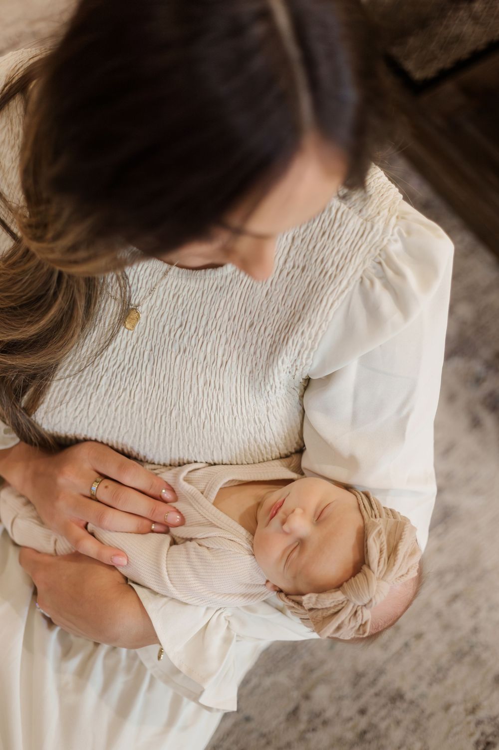 Close-up view of tender nurturing moments captured in soft natural light on textured gray fabric.