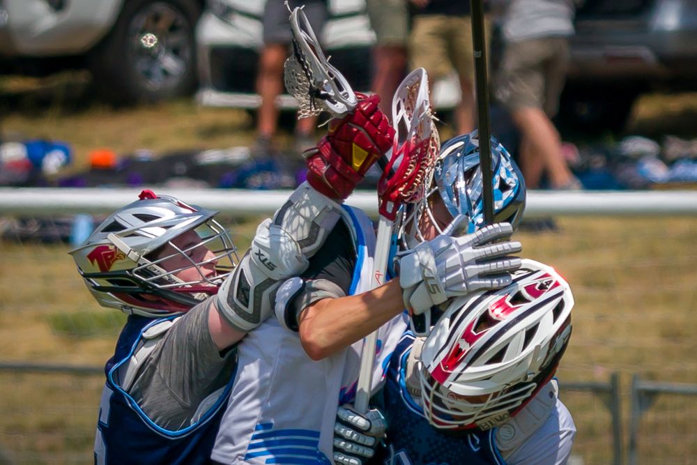 American football players compete aggressively for ball possession during an intense match on grass field.