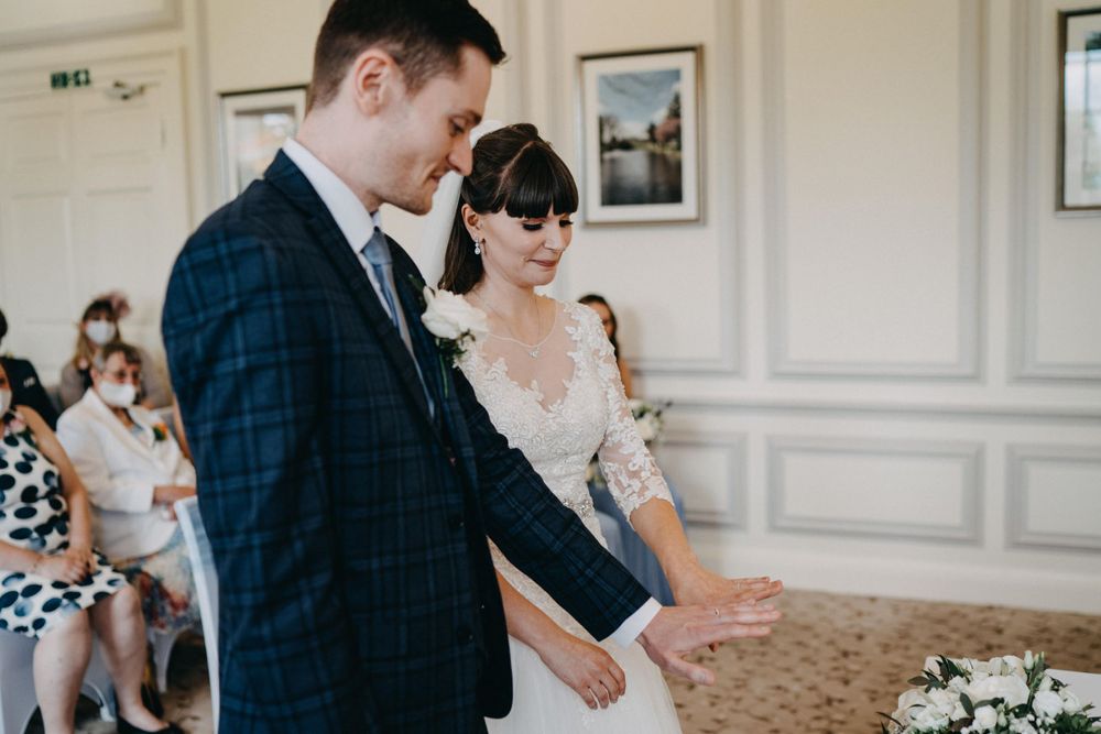 Wedding ceremony in elegant room at Harrowden Hall with classic decor and ornate details.