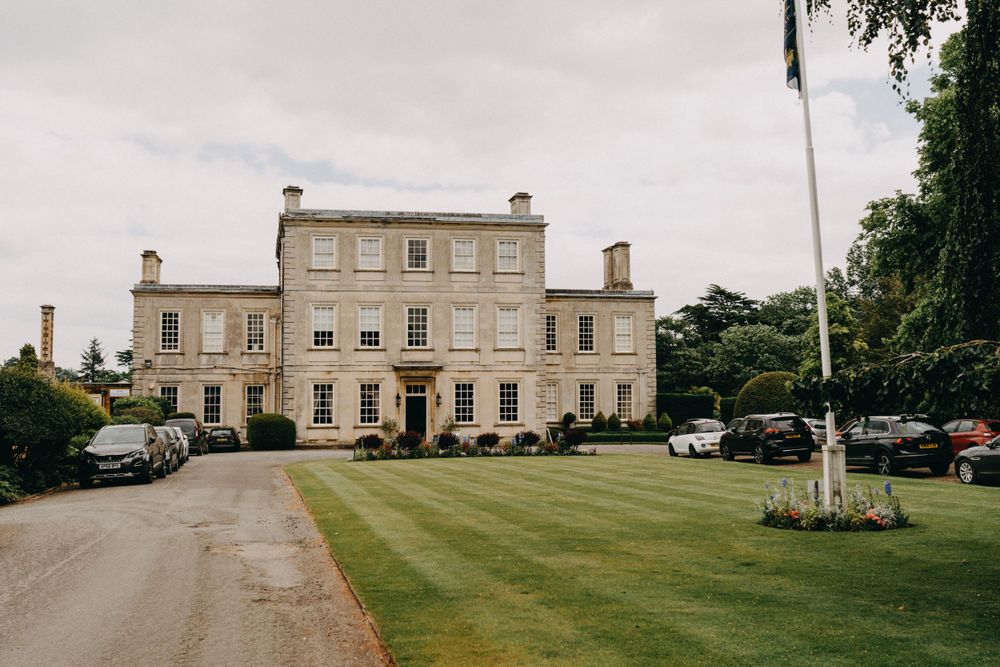 Harrowden Hall - grand historic mansion venue with manicured grounds and parked cars.
