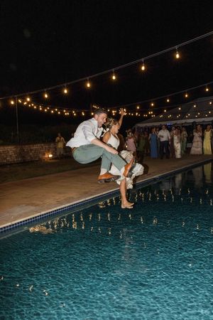 Mary and Kodie jump in the pool at the end of their wedding at the Pine Island Lodge in Corolla, Outer Banks, NC. East Coast Wedding Photo.