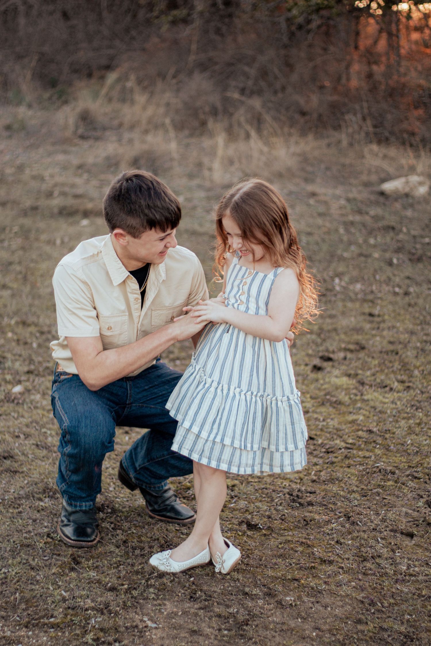 Tender moment captured outdoors at sunset as a pair share a special connection while wearing casual dress clothes.