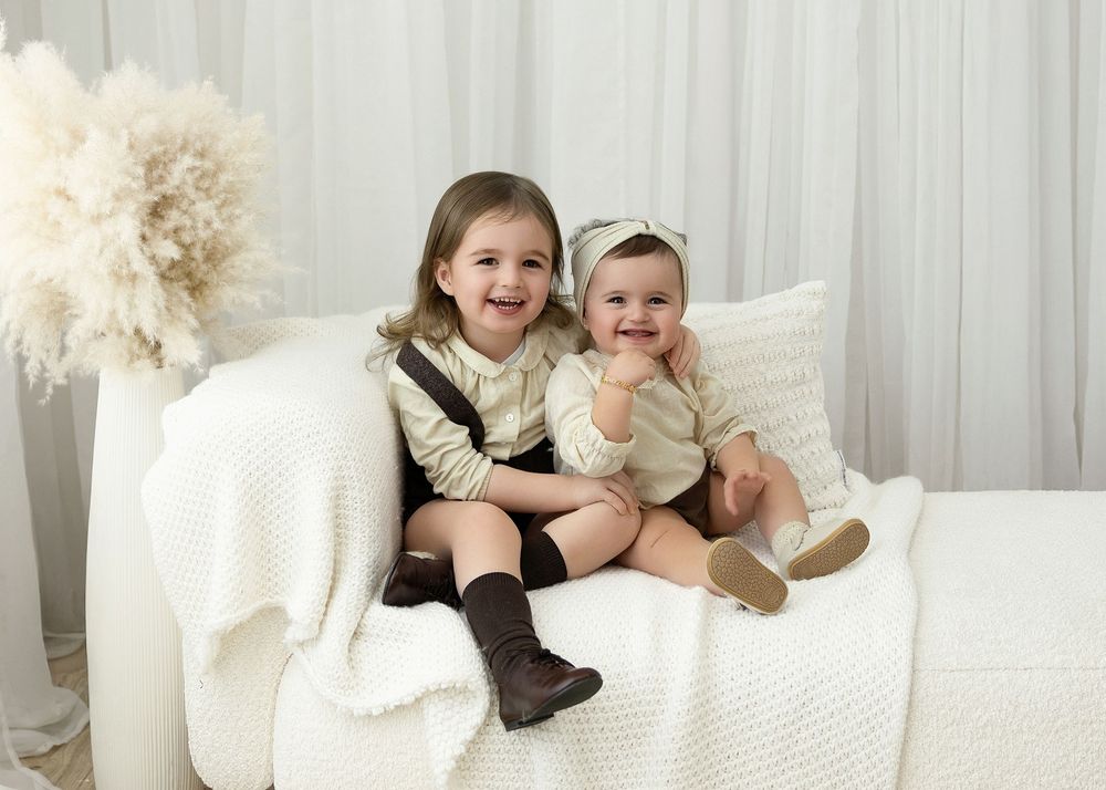 A collage of family photos showing people lounging on white bedding and pillows in casual intimate moments.
