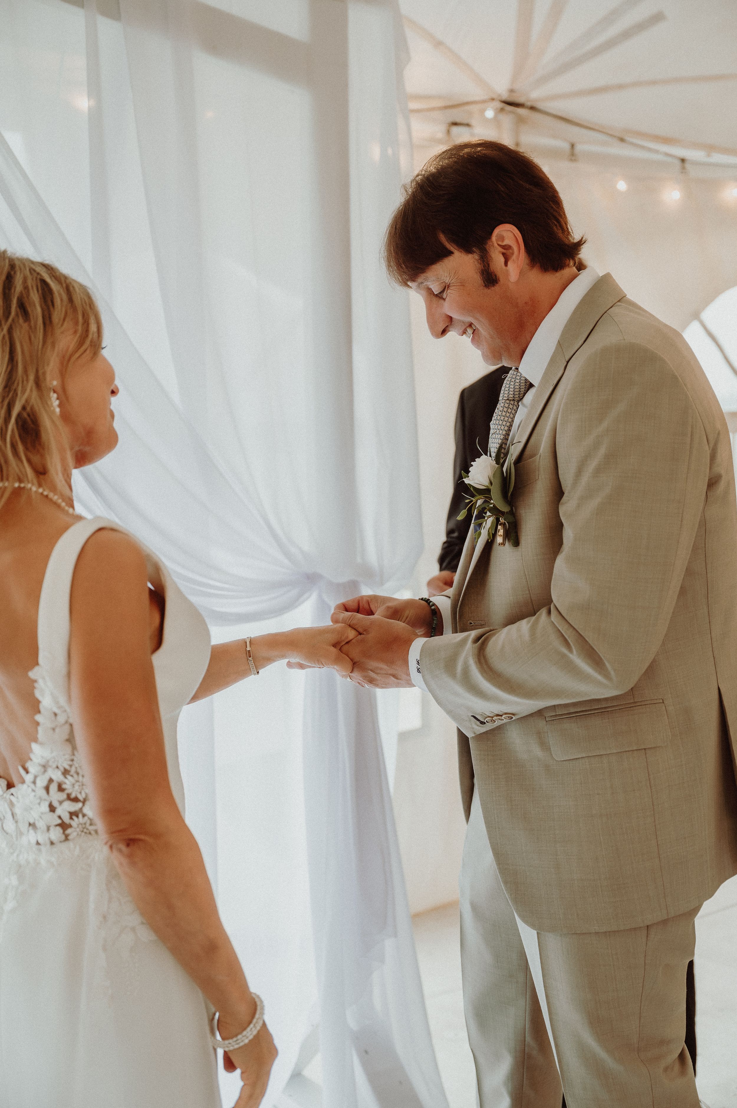 Couple shares intimate moment during ring exchange at wedding ceremony.