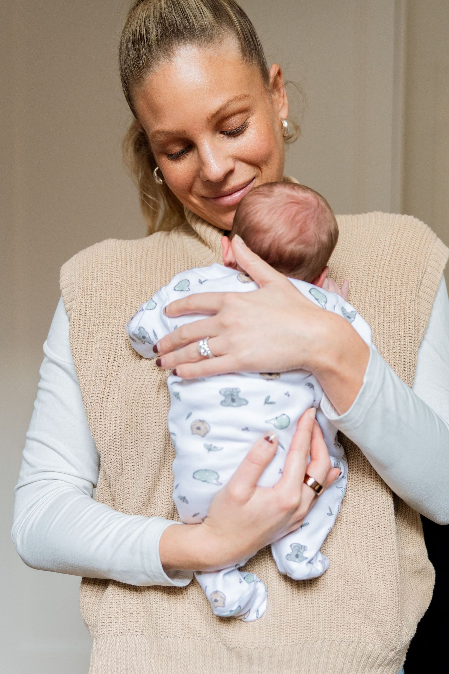 Tender moment of parent holding sleeping baby in sunlit setting.