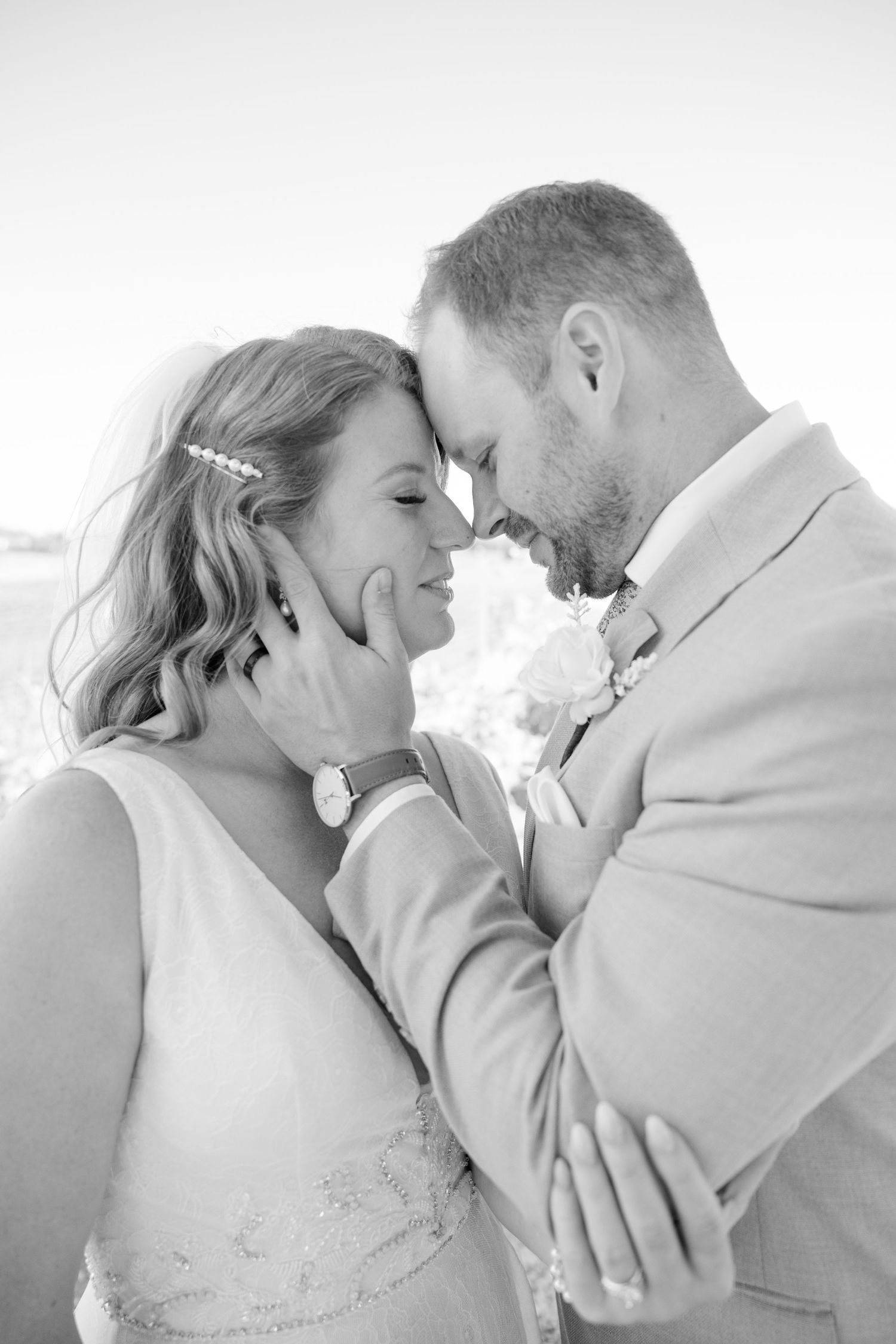 A romantic black and white portrait of a tender moment between newlyweds.