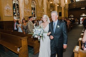 An elegant church wedding processional with light streaming through stained glass windows.