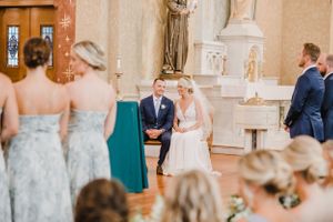 A wedding ceremony taking place in a traditional church sanctuary with elegant decor.