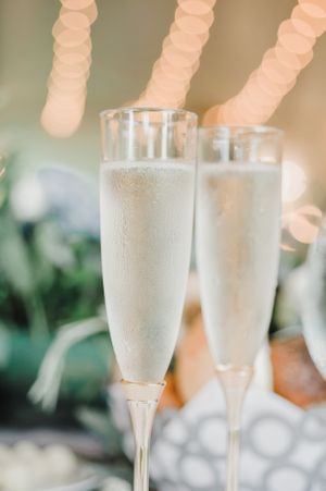 Two elegant champagne flutes with bubbles against a soft bokeh background.