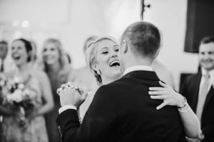 Black and white candid photo of a joyful first dance moment at a wedding.