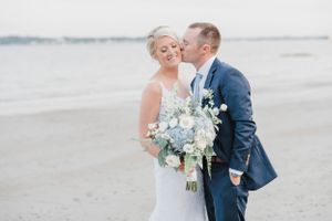 Romantic wedding portrait on a beach with white and blue florals.