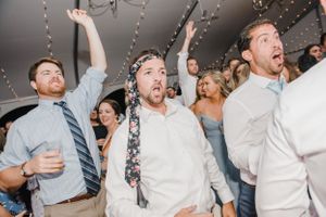 Energetic wedding guests dancing and celebrating at reception.