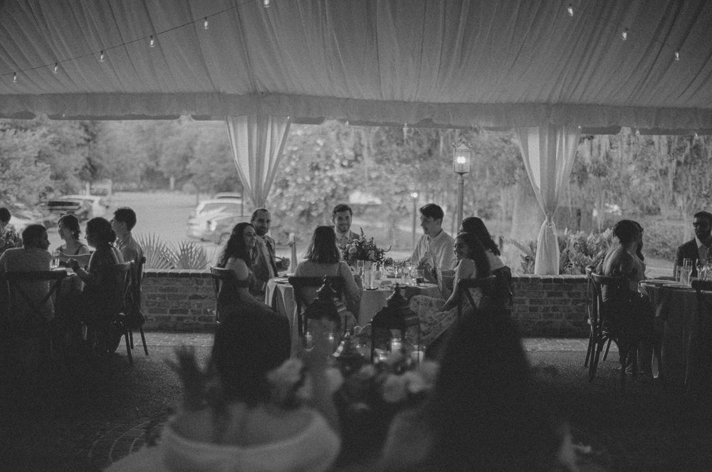 A series of black and white photos showing guests mingling at a formal event in an elegant reception venue.