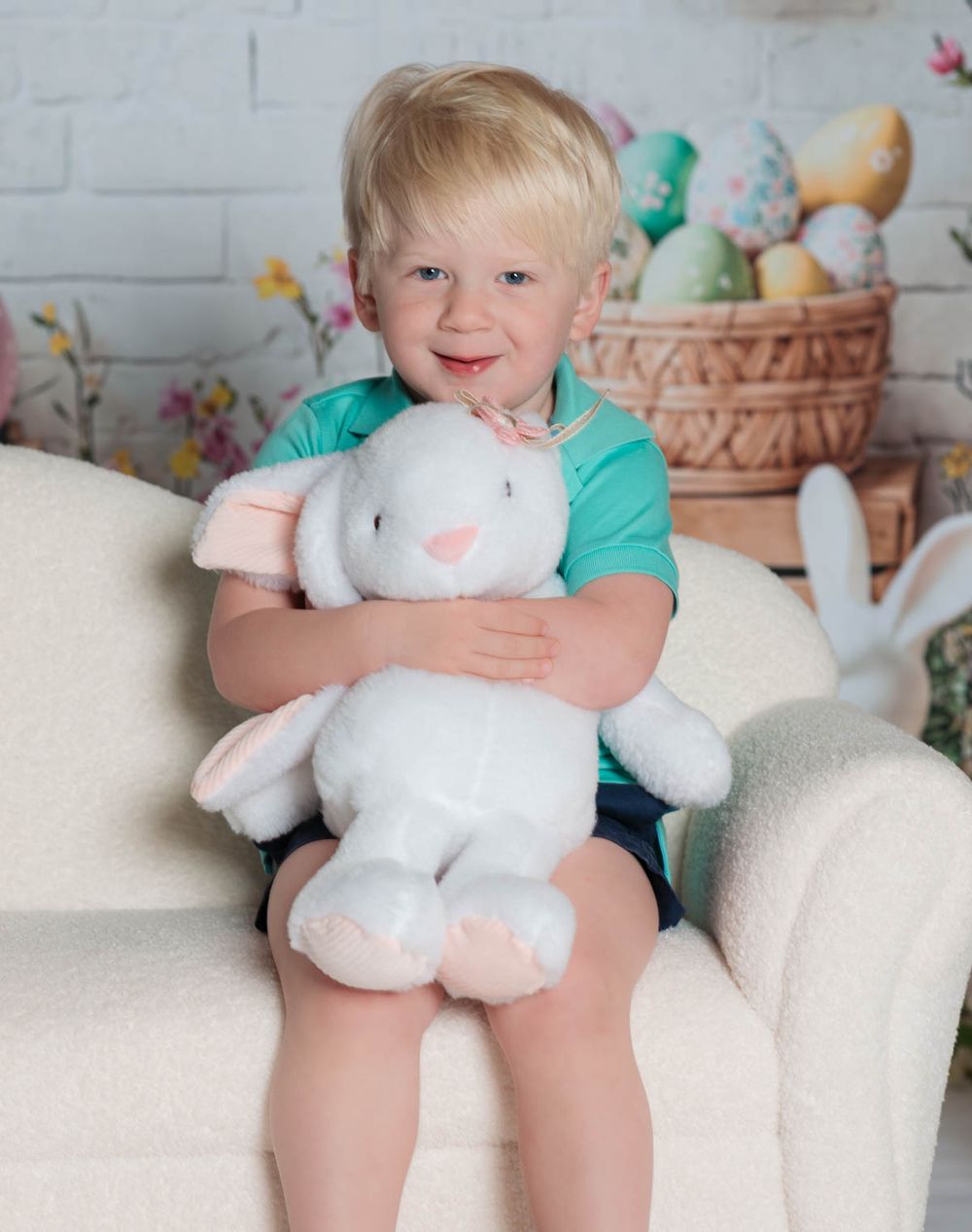A soft white bunny plush toy sits on a couch with Easter decorations in the background.