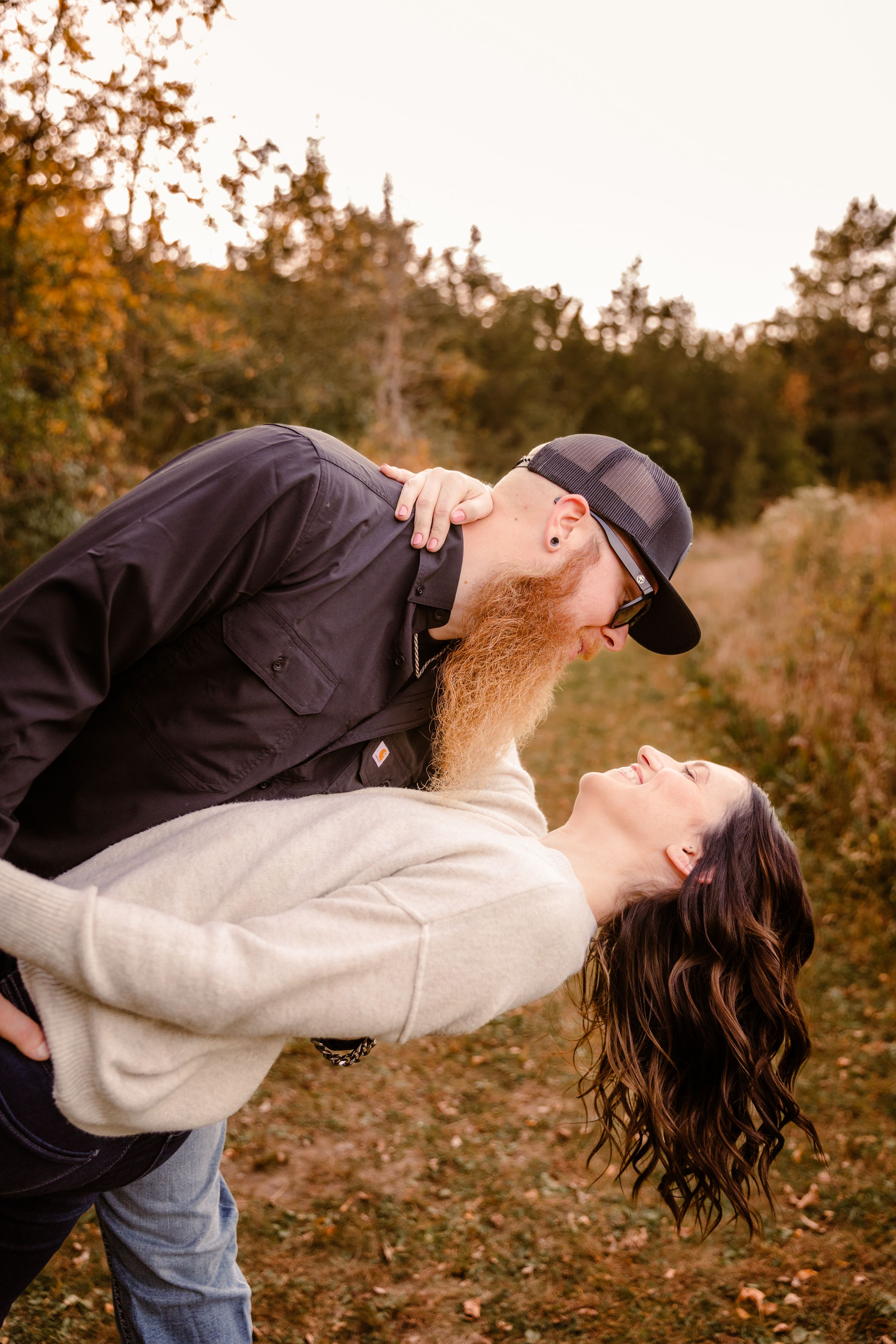A romantic dip pose captured during an autumn outdoor photoshoot.