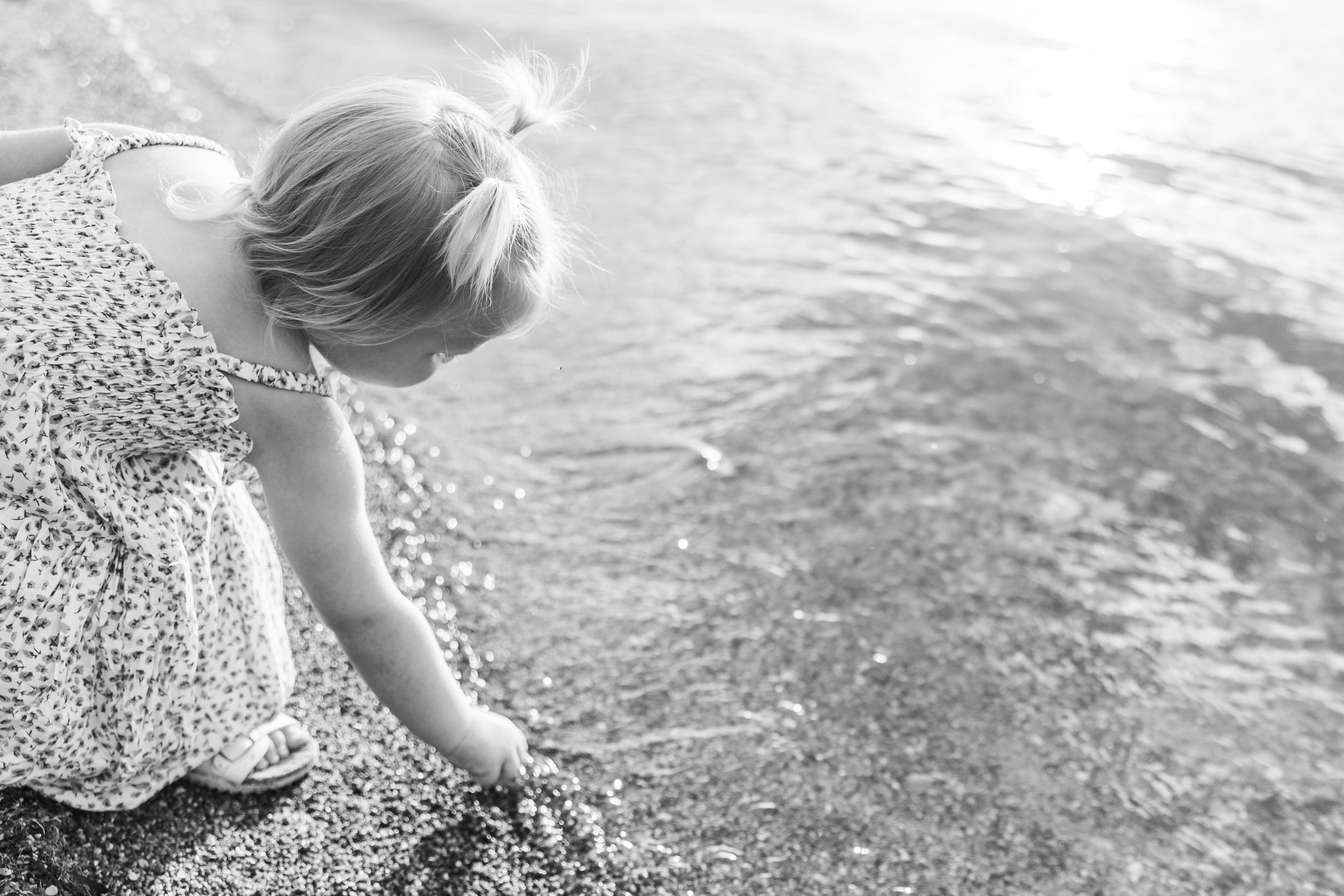 Child playing in shallow water on a sunny day.