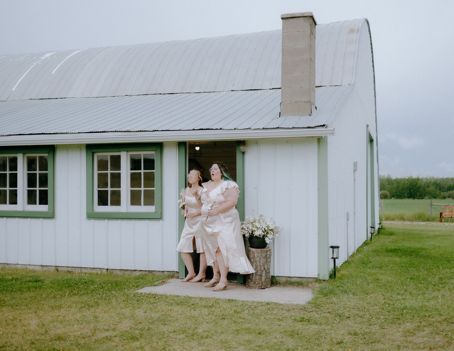 A charming white farmhouse with green windows features a welcoming front entrance.