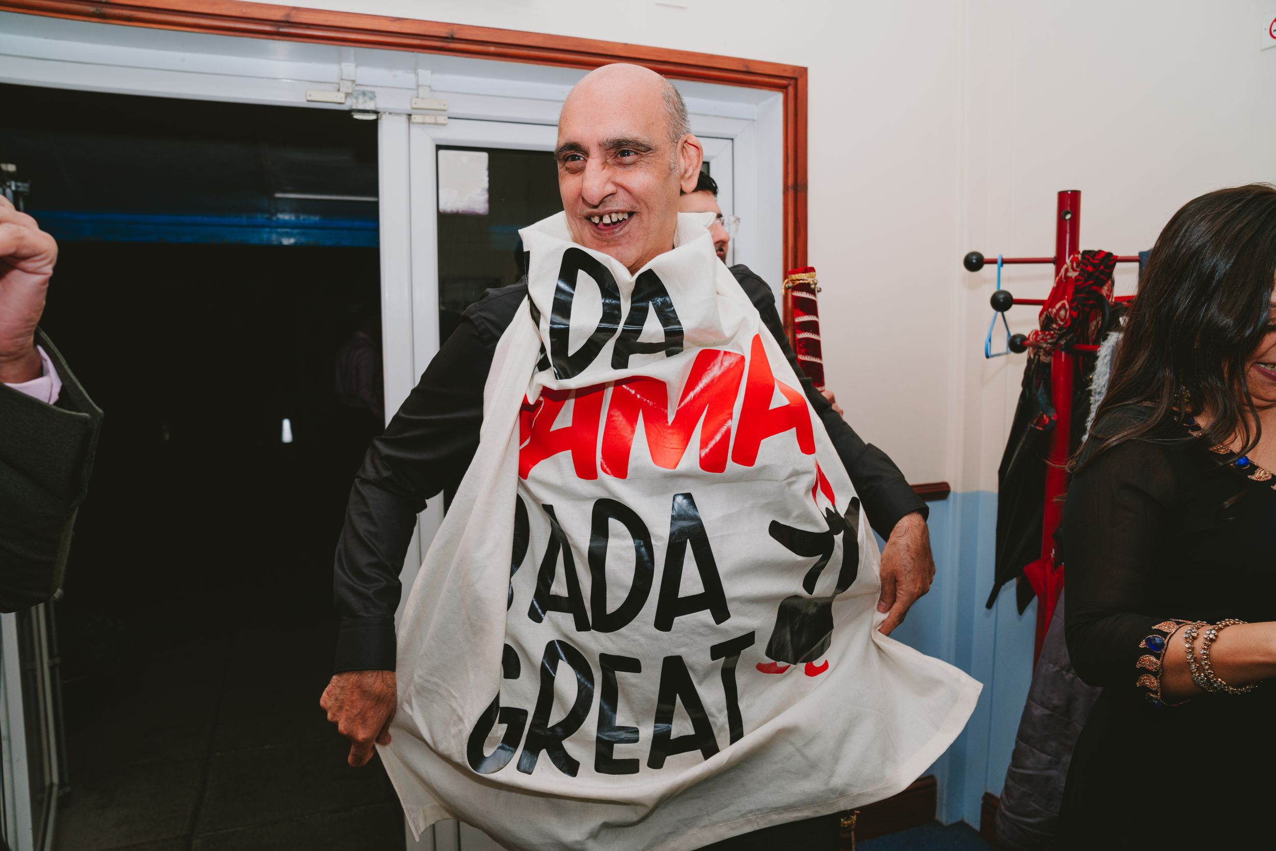 Person wearing statement white hoodie with text design at indoor event venue.