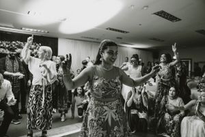 Black and white photo of dancers enjoying themselves at a lively indoor celebration.